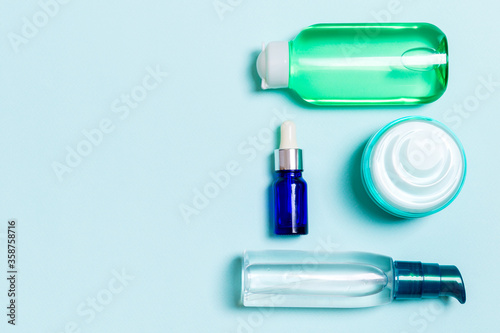 Cosmetics SPA branding mock-up, top view with copy space. set of tubes and jars of cream flat lay on blue background