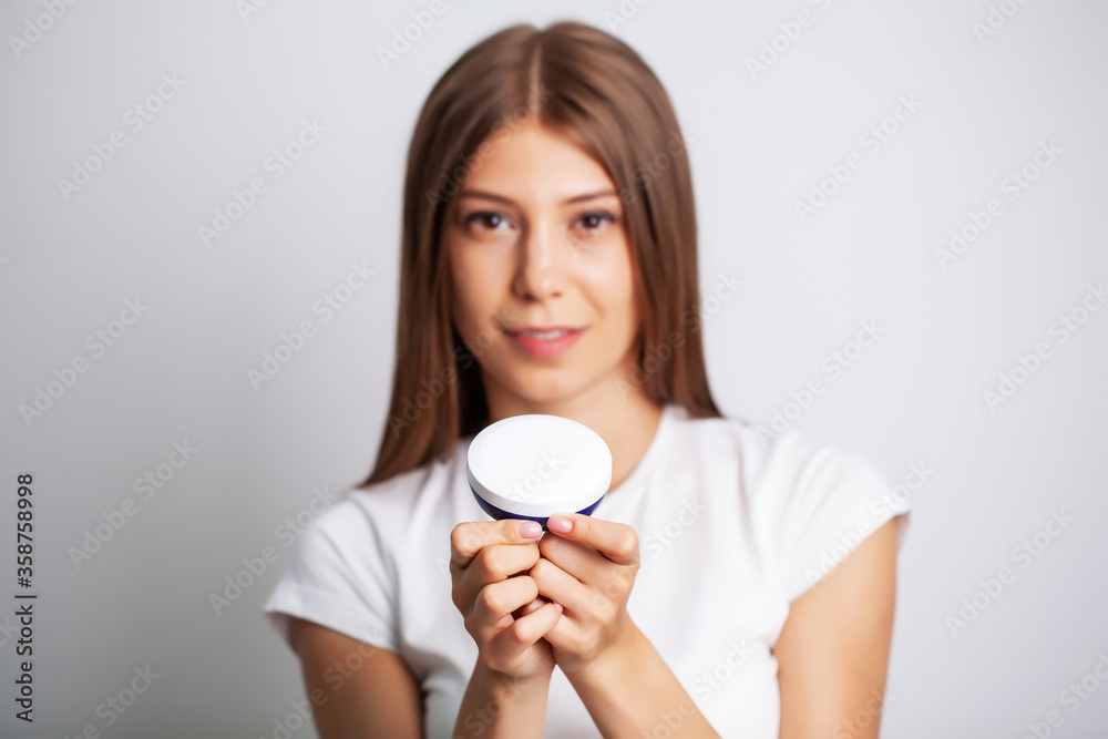 Skin care, woman with beauty face holding facial skin cream Skin care, woman with beauty face holding facial skin cream