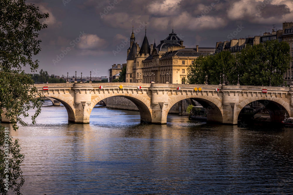 Paris, France - June 9, 2020: Nice view of Pont Neuf bridge and Conciergerie in background on a stormy end of the day in Paris