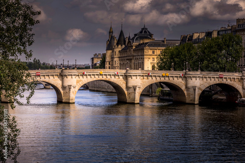 Paris, France - June 9, 2020: Nice view of Pont Neuf bridge and Conciergerie in background on a stormy end of the day in Paris