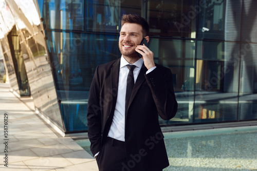 Businessman Talking on Phone Isolated. Business man Standing Full Length with Phone in Hand