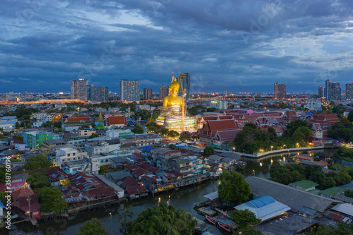 Photography Aerial view of the Giant Golden Buddha in Wat Paknam Phasi Charoen Temple in Phasi Charoen district on Chao Phraya River at night, Bangkok