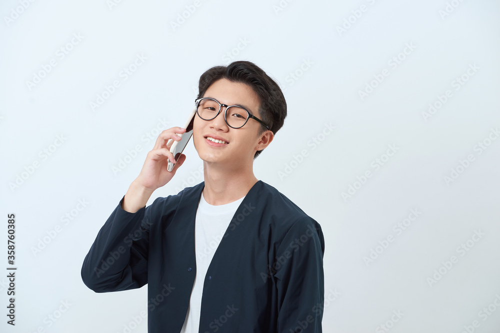 oung good looking Asian man in casual style holding a smartphone oung good looking Asian man in casual style holding a smartphone