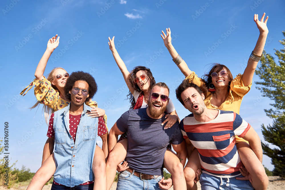 Obraz premium Young men giving his girlfriends a piggyback ride