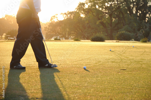 Adult Man Playing Golf at sunset