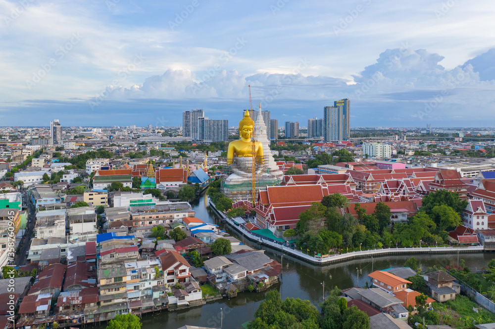 Fototapeta Aerial view of the Giant Golden Buddha in Wat Paknam Phasi Charoen Temple in Phasi Charoen district on Chao Phraya River at sunset, Bangkok. Urban town, Thailand. Downtown City.