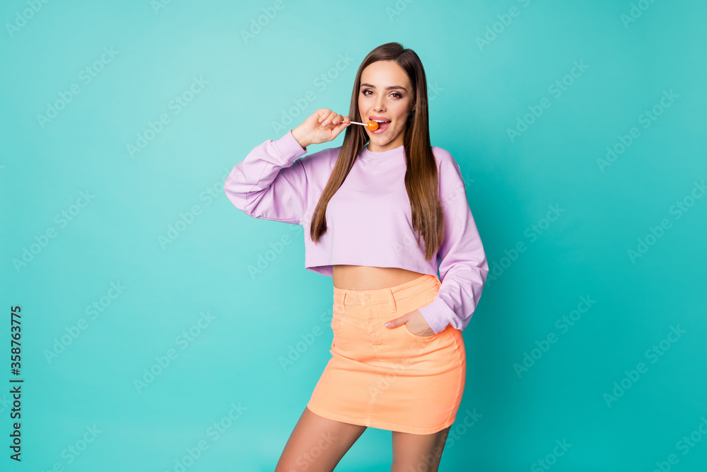 Photo of pretty tender lady hold lollipop hands good mood sweets addicted person lick bite tasty candy wear cropped pullover orange short skirt isolated teal color background Photo of pretty tender lady hold lollipop hands good mood sweets addicted person lick bite tasty candy wear cropped pullover orange short skirt isolated teal color background
