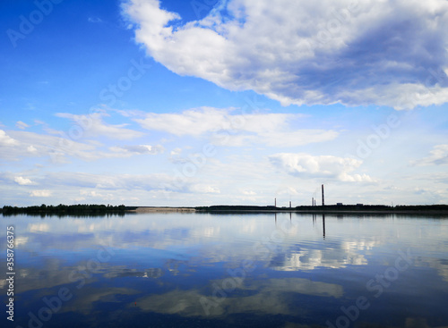 Fototapeta Naklejka Na Ścianę i Meble -  Clouds on a blue sky with reflection in water