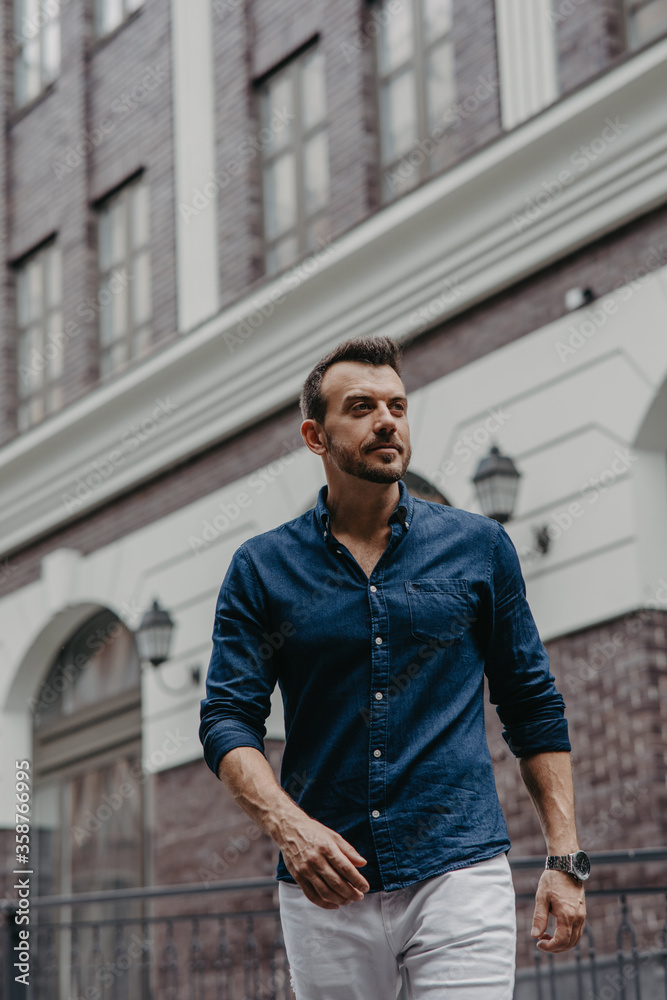 Young man goes at street near building. Young man goes at street near building.