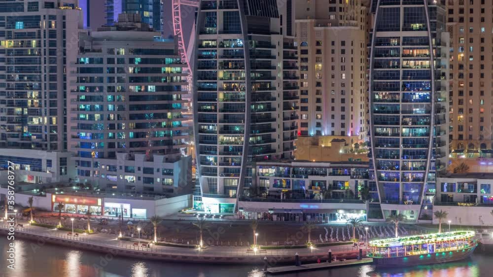 Dubai Marina after sunset with skyscrapers and promenade aerial day to night transition timelapse. Modern towers and boats from above, port with luxury yachts. United Arab Emirates Dubai Marina after sunset with skyscrapers and promenade aerial day to night transition timelapse. Modern towers and boats from above, port with luxury yachts. United Arab Emirates