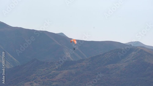 paraglider flying in the mountains photo