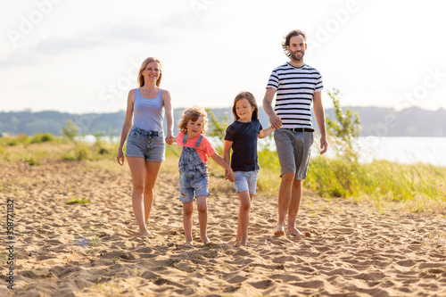 Young family enjoying time at the beach   © pikselstock