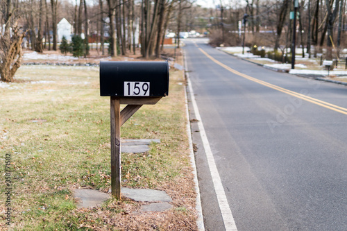 Black metal mailbox number 159 before Glenside Ave in Scotch Plains, New Jersey. Empty street. Cold winter. No traffic, no cars.