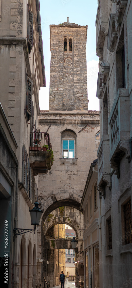 Tall roman style belltower with a clock on top of it inside the Diocletians palace, also known in Croatian as 
