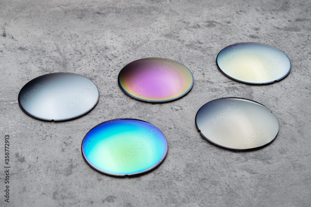 © Arsenii - Close up of optical lenses for sunglasses with different color. Production and adjust of new eyeglasses lens in optics. Eyesight concept © Arsenii - Close up of optical lenses for sunglasses with different color. Production and adjust of new eyeglasses lens in optics. Eyesight concept