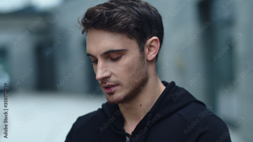 Closeup smiling man wearing wireless earphones. Male runner listening music Closeup smiling man wearing wireless earphones. Male runner listening music