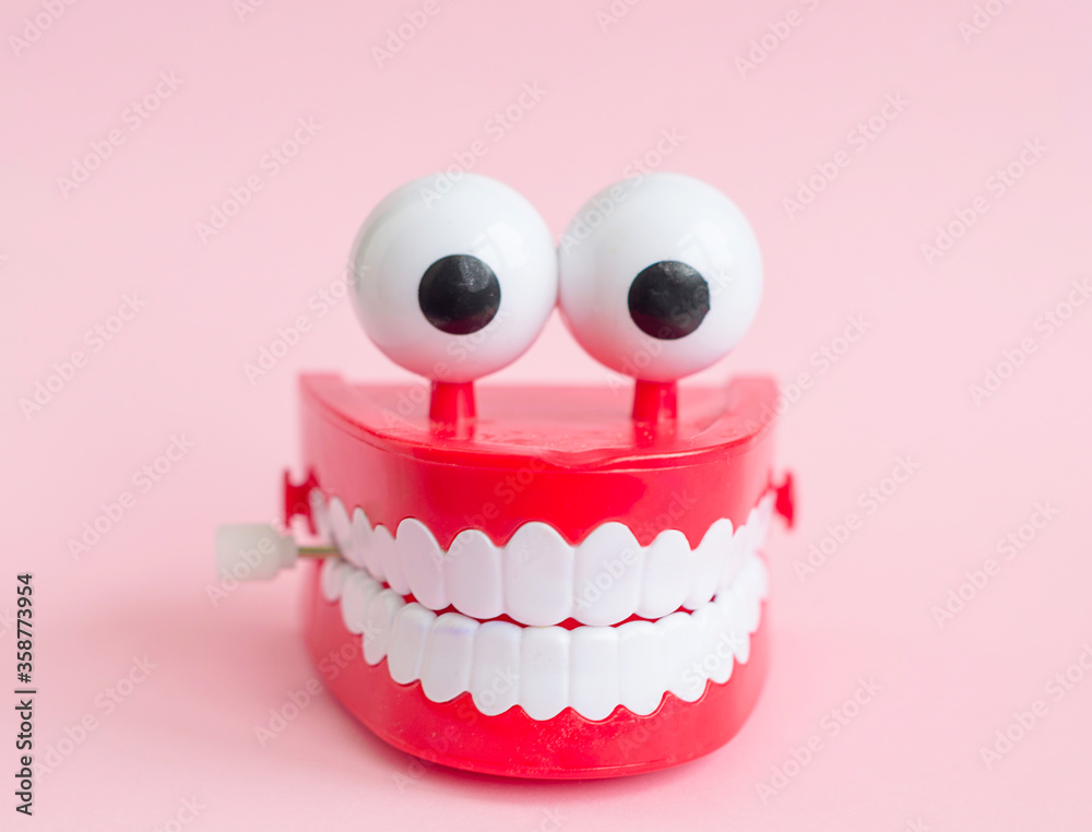 toy with smiling teeth and eyes on pink background as a concept of dentistry and healthy oral cavity and smile toy with smiling teeth and eyes on pink background as a concept of dentistry and healthy oral cavity and smile