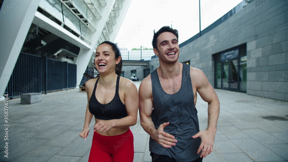 Close up cheerful couple running outdoor. Laughing man and woman training run Close up cheerful couple running outdoor. Laughing man and woman training run