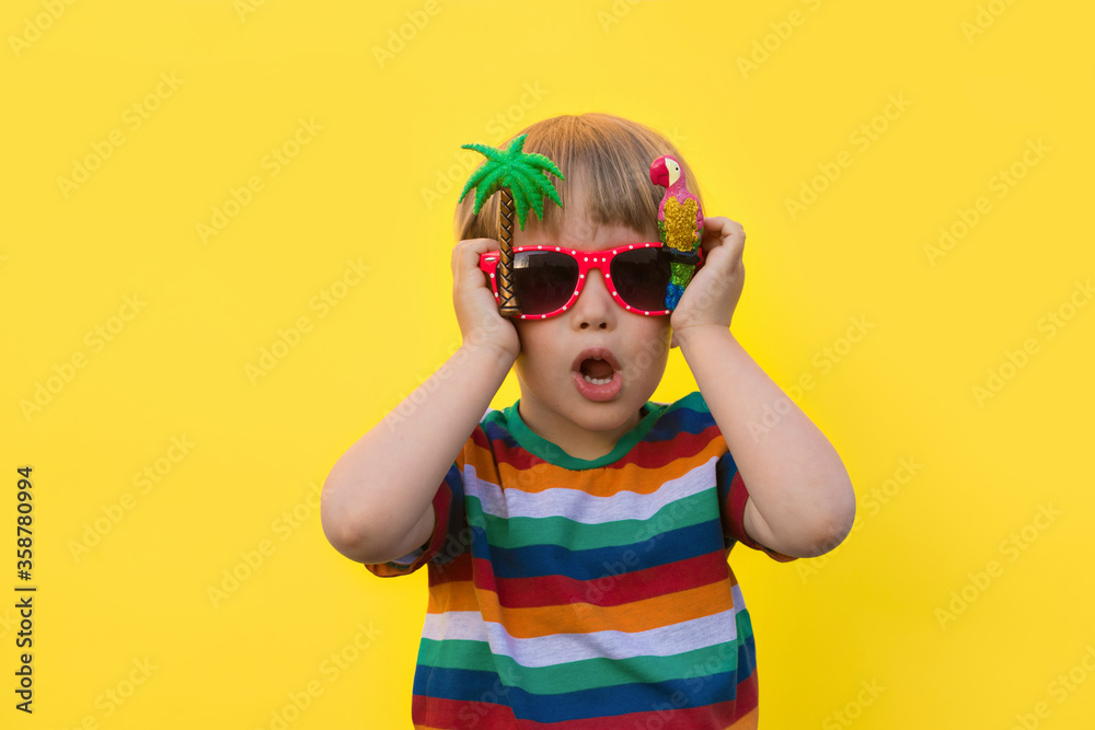 Summer Boy. Toddler in a rainbow t-shirt poses in front of the color striking backgrounds