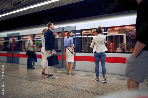 Fotografie young business people at subway station waiting for a train.