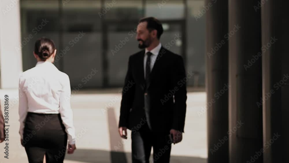 Business man walking outdoors near office building meeting female colleagues and smile to them. Business concept. Selective focus. Prores 422. Business man walking outdoors near office building meeting female colleagues and smile to them. Business concept. Selective focus. Prores 422.