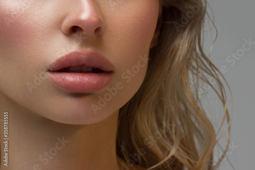 Close-up of woman's Lips with Fashion pink Make-up and Manicure on Nails. Beautiful female full lips with perfect Makeup. Part of female face. Macro shot of beautiful make up on full lips