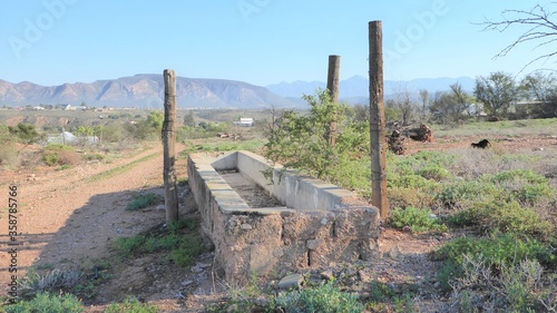 Rustically Crumbling old Water Trough by Dirt Track into a Little Karoo Village