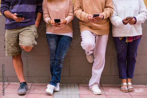 group of people using their cellphones and smartphones together and looking at it - online lifestyle and concept - addicted at phone and technology