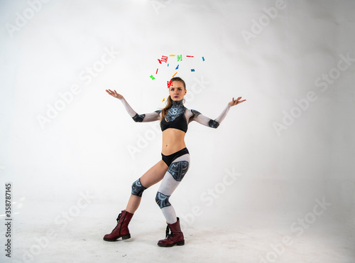 beautiful brunette girl in a robot suit takes gymnastic poses on a white background