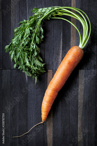 Fotografi Freshly picked carrot on a wooden table.