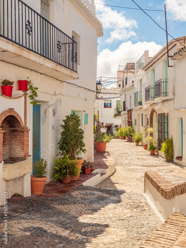 Frigliana costa Del Sol Spain narrow streets winding between houses with colorful potted plants and cobbled road