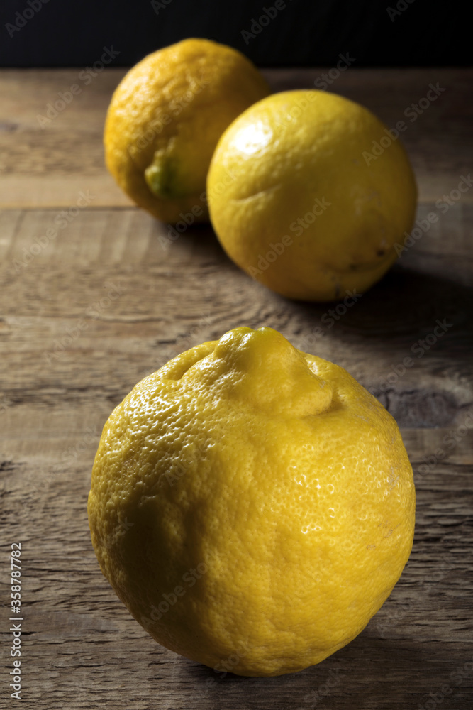 Fresh biologic lemons on a wooden table.