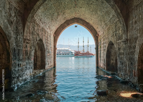 фотографія View of pleasure tourist yachts through the stone arch of an old shipyard in Tur
