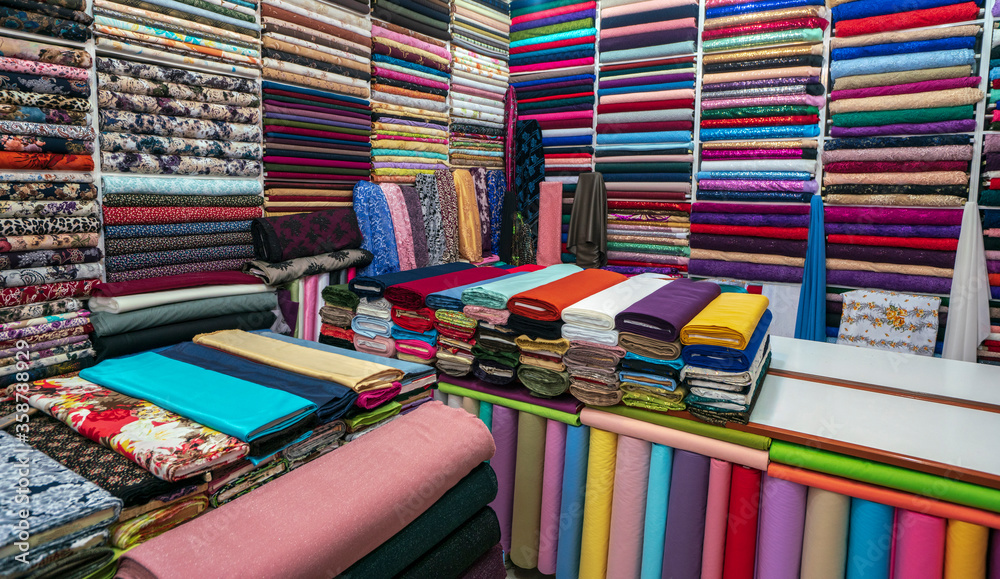 Rolls of fabric and textiles in a factory shop. Multi different colors and patterns on the