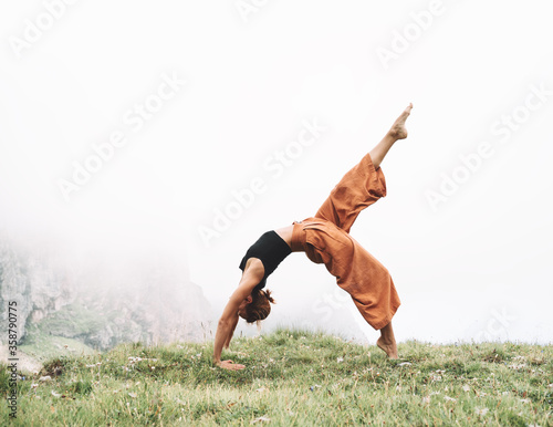 Yoga on nature. Young woman is practicing yoga in mountains photo