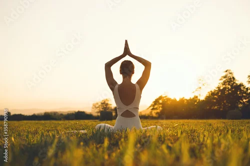 Obraz Young woman practicing yoga on nature.