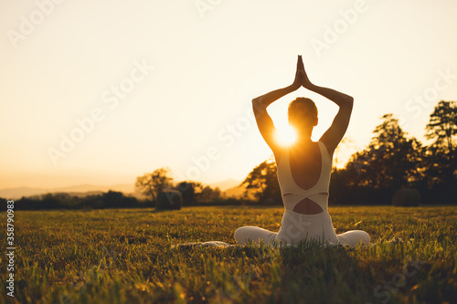 Young woman practicing yoga on nature.