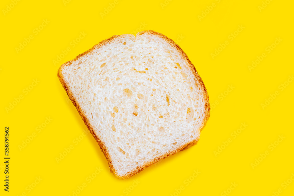 Close up photo of fresh baked toast bread on yellow background. Top view. Bread for breakfast.