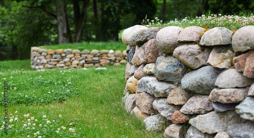 Fotografering Grass and flowers with stone masonry on the leveled front yard