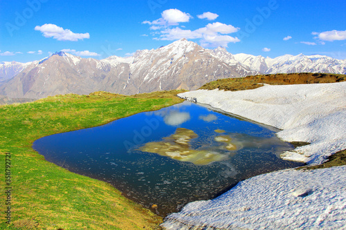 snowy mountains  blue water and blue sky 