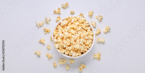 Salted popcorn in bucket on white background. Top view. Copy space