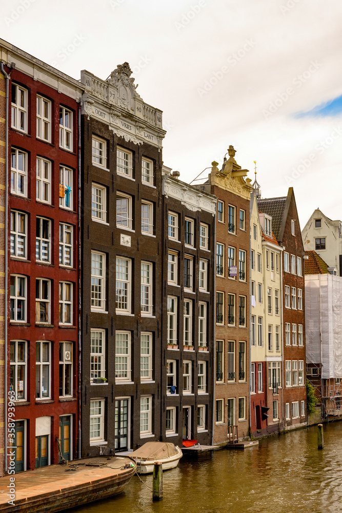 Buildings in front if the Damrak street, Amsterdam, the capital of the Kingdom of Netherlands