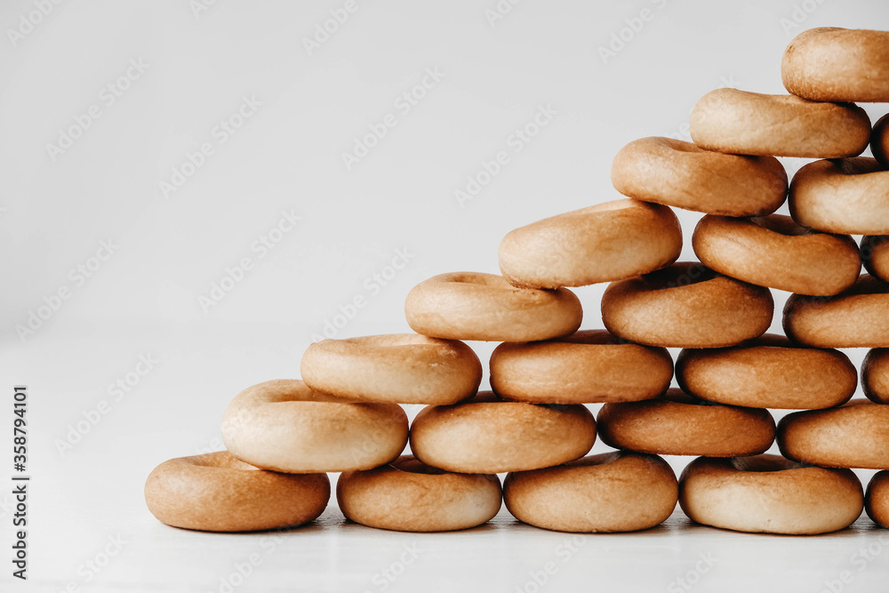 Drying or mini round bagels in the shape of a pyramid on a white wooden background. Copy, empty space for text Drying or mini round bagels in the shape of a pyramid on a white wooden background. Copy, empty space for text