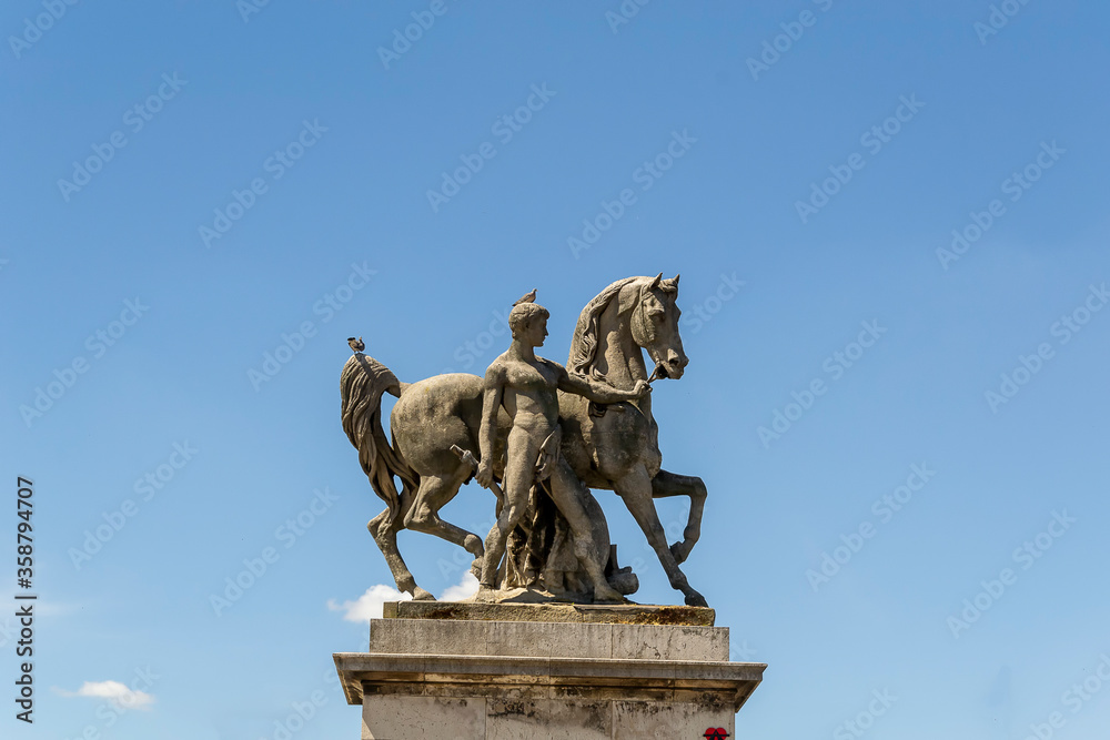 Photo d'une colonne surmontée d'une statue en bronze d'un cheval et son cavalier 