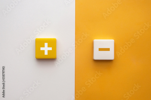 Plus and minus signs on a multi-colored background. Positive and negative information photo