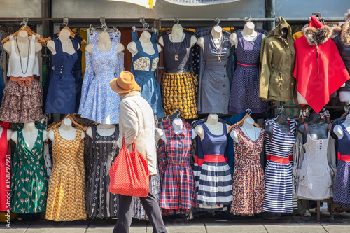 An unidentified tourist browsing a range of sundresses on display at Camden market in London photo