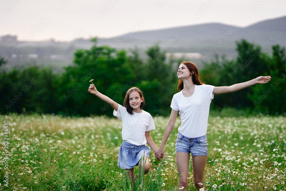 Fototapeta premium Beautiful woman and little girl in nature