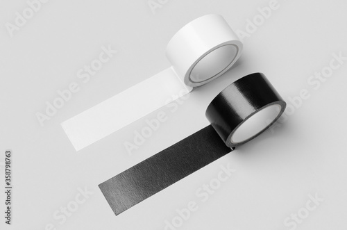 White and black unrolled duct tapes mockup on a grey background. photo