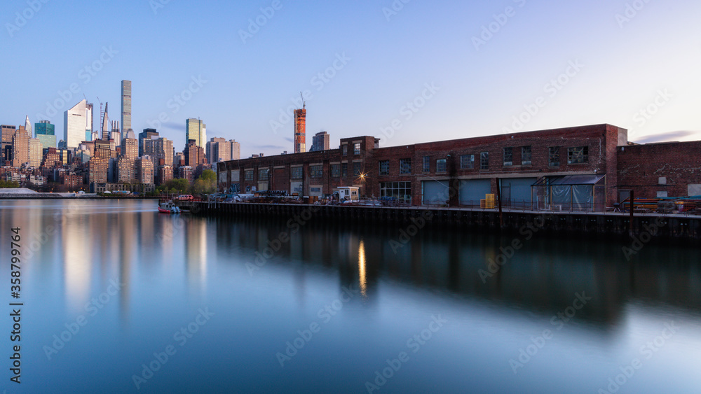 View on Midtown Manhattan from Queen's pier during sunrise with long exposure