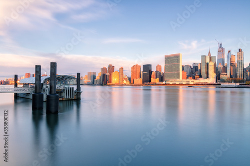 View on Midtown Manhattan and from East river with ferry stop during sunrise with long exposure © Andriy Stefanyshyn